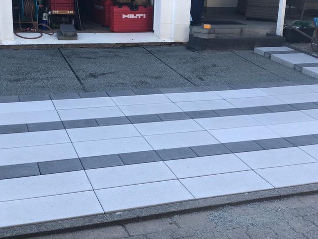 Verlegung einer weißen Terasse mit schwarzem Linie